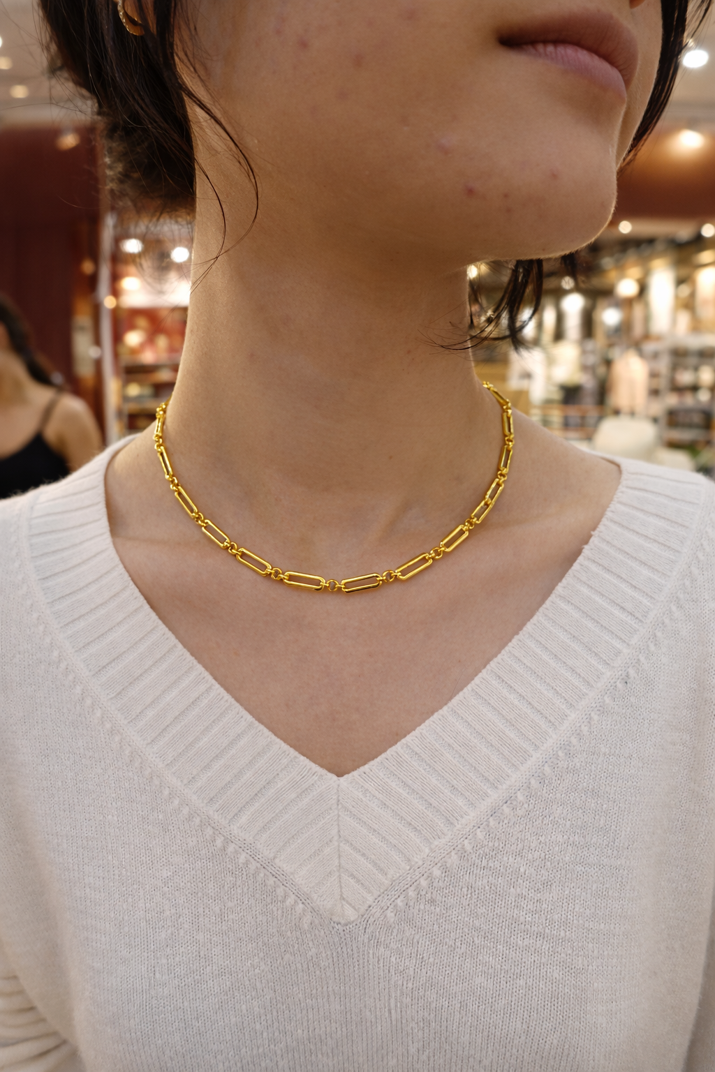 Gold plated chain necklace worn by a person 