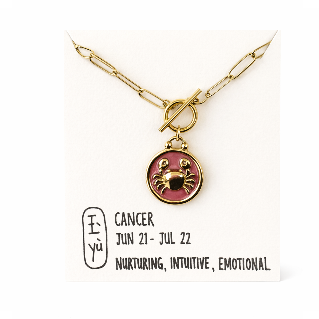 Gold plated necklace with a pink pendant featuring a crab design,.