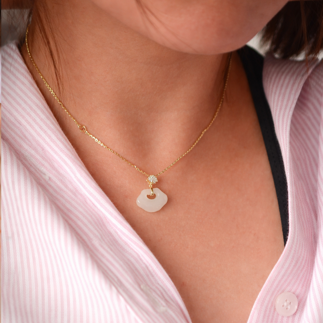 Gold plated sterling silver jade necklace with a pendant worn by a person 