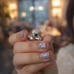 Close-up of a hand wearing a sterling silver ring with a blue gemstone 