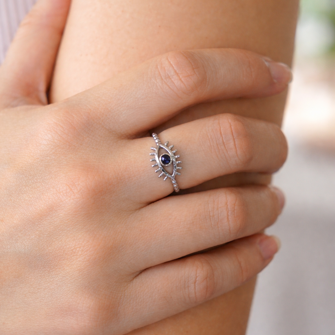 sterling silver ring with a blue gemstone on a person's finger 