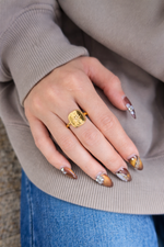 close up shoot of hand wearing Cosmic a gold ring with a star design