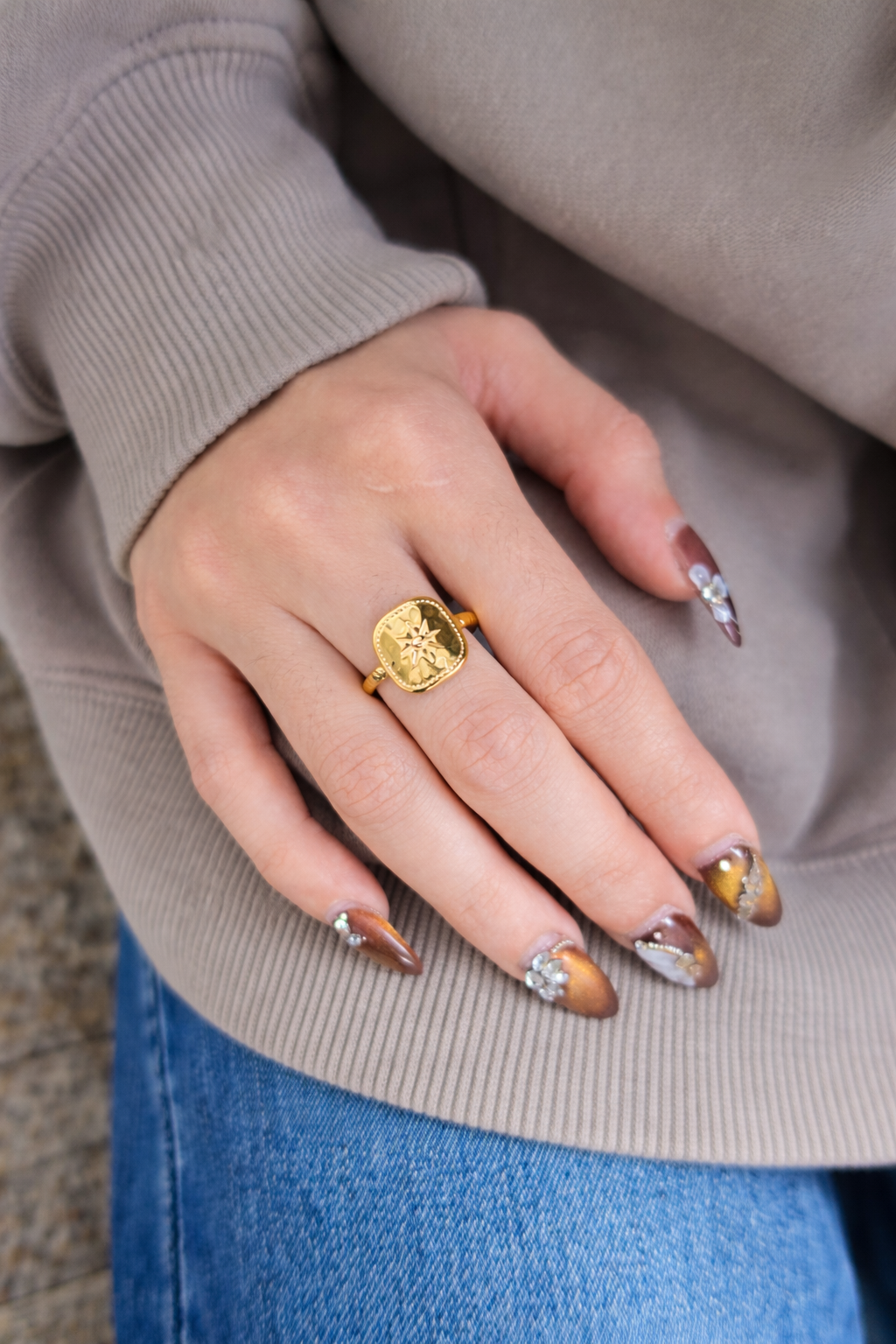 close up shoot of hand wearing Cosmic a gold ring with a star design