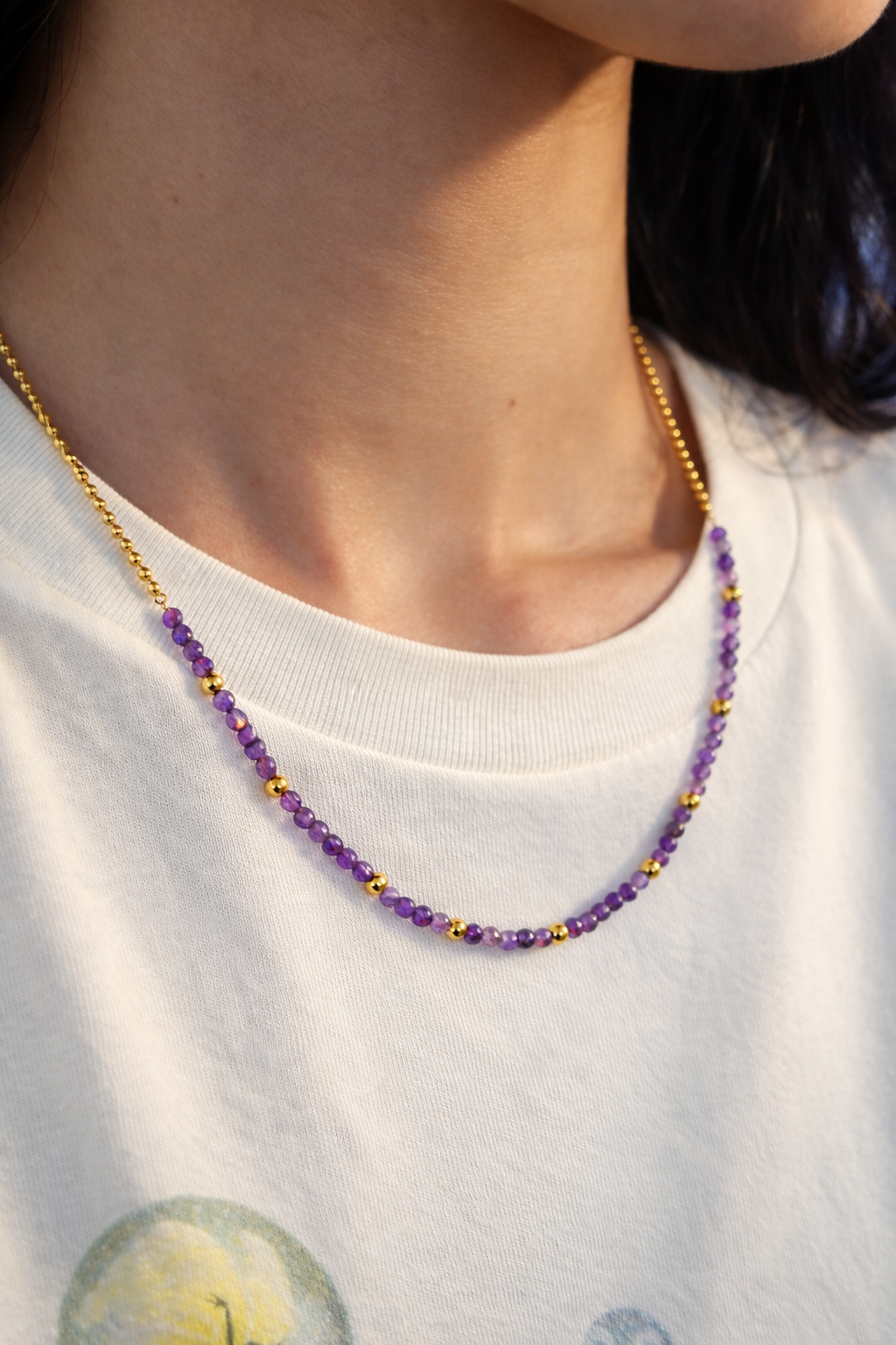 Linked joy  person wearing a purple beaded necklace .