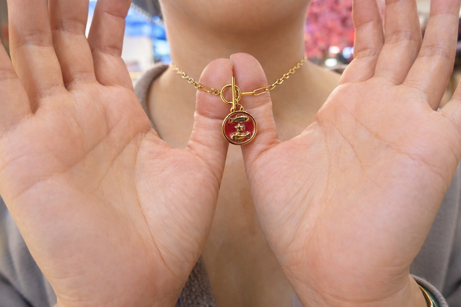 Gold plated necklace with a red pendant with fish design