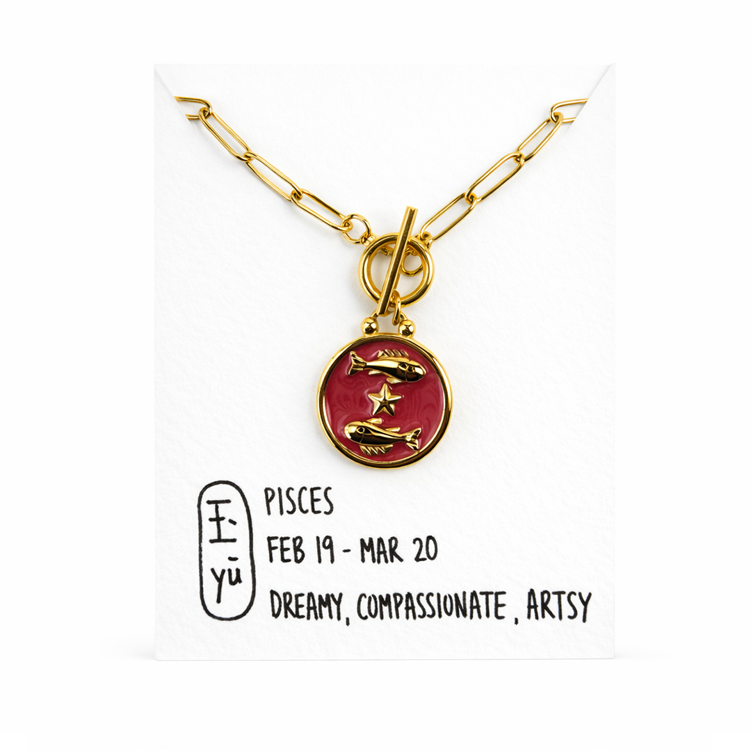 Gold plated necklace with a red pendant featuring Pisces symbols 