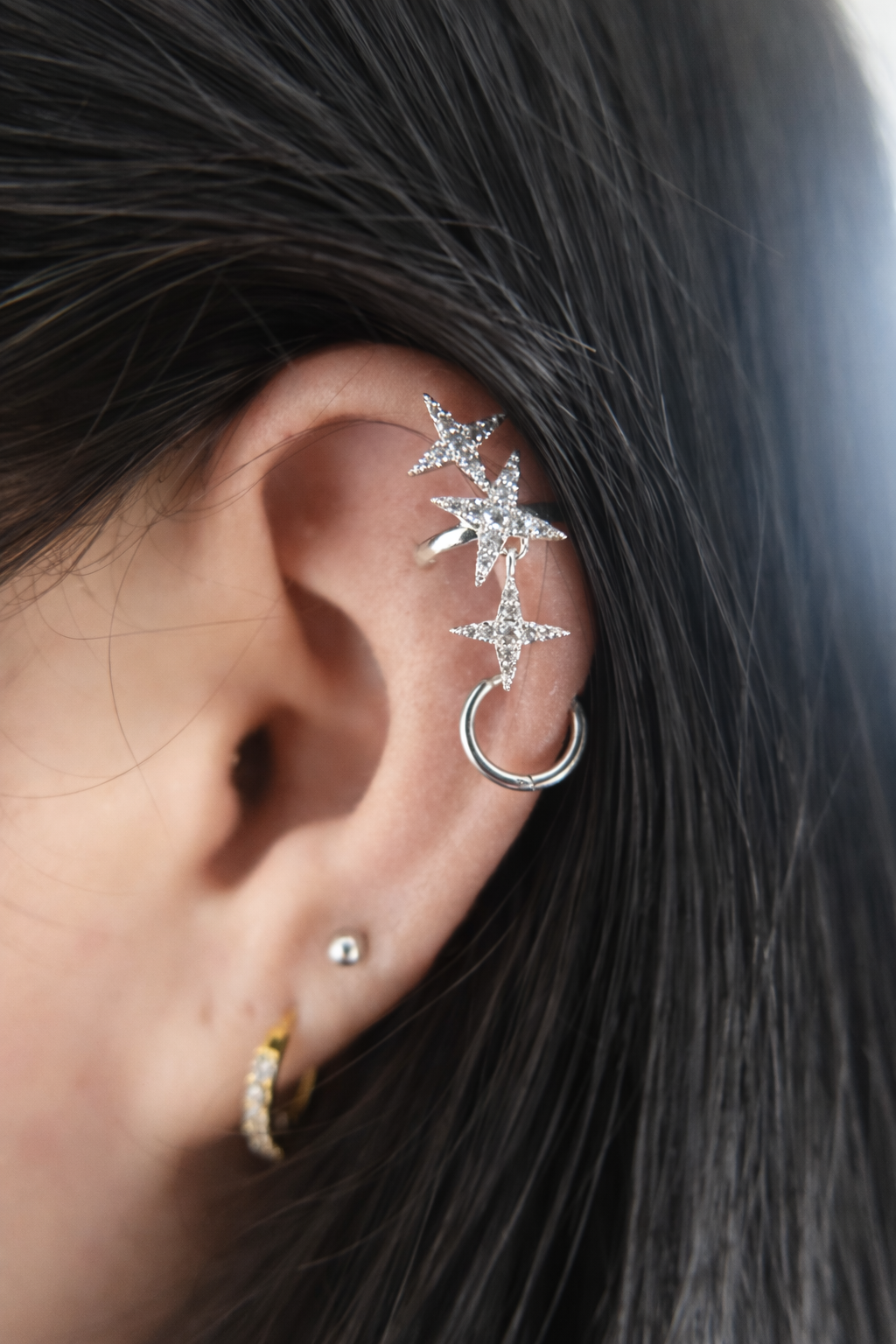 Close up of an ear with star-shaped earrings 