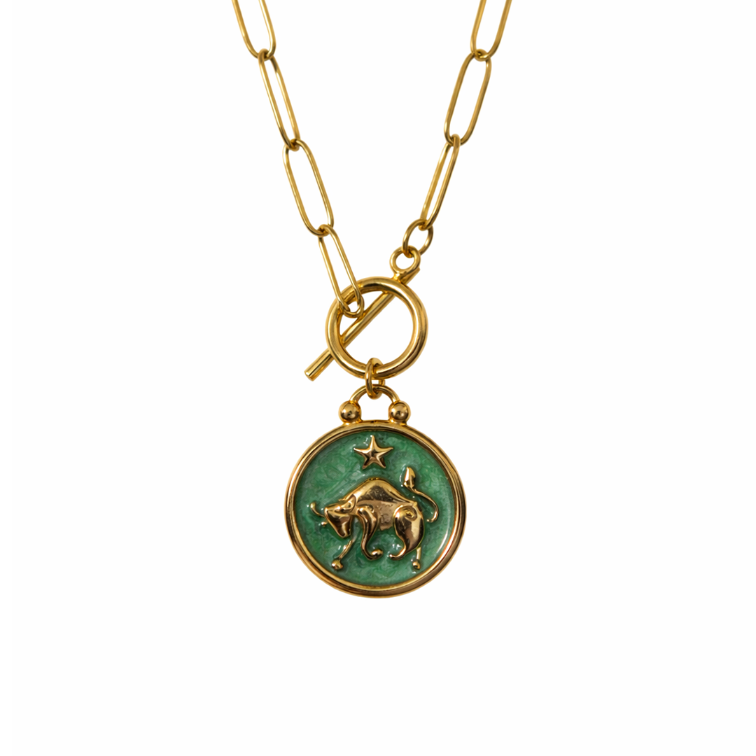 Gold plated necklace with a green pendant featuring a star and bull design 